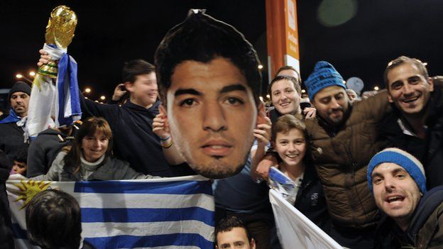 Uruguay fans celebrate with a Luis Suarez mask