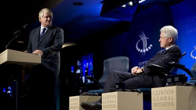 Bill Clinton escucha a Dennis O'Brien, director de Digicel mientras da su discurso en un evento de Iniciativa Global Clinton.