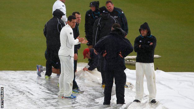 New Zealand's players help the ground staff put the covers on at Grace Road