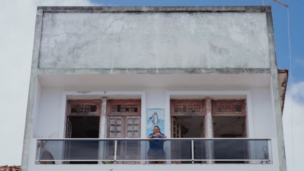 Peixinho na sacada de sua casa, que traz uma pintura de Iemanjá