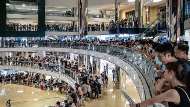 Residents and protesters sing songs and shout slogans as they gather at a shopping mall after business hours in Tai Koo district