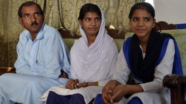 அசியா பீபியின் கணவர் ஆஷிக் மசிக் (இடது), மகள்கள் ஈசா (நடுவில்) மற்றும் இஷாம் (வலது)