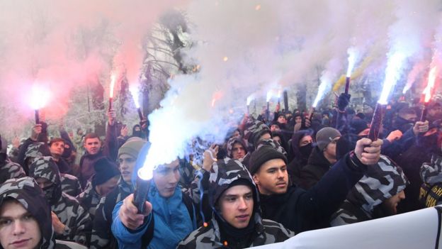 Activists of Ukrainian far-right parties hold flares during a rally at the Ukrainian parliament