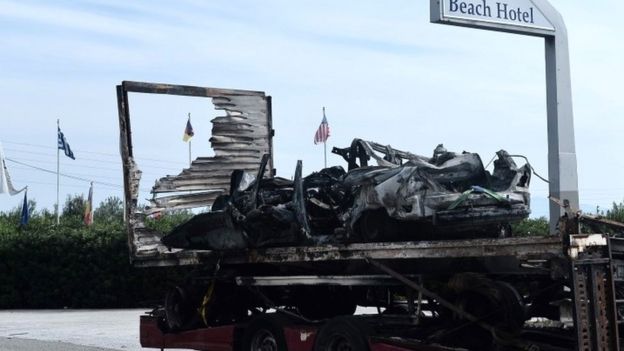 The burned-out car is retrieved near Kavala