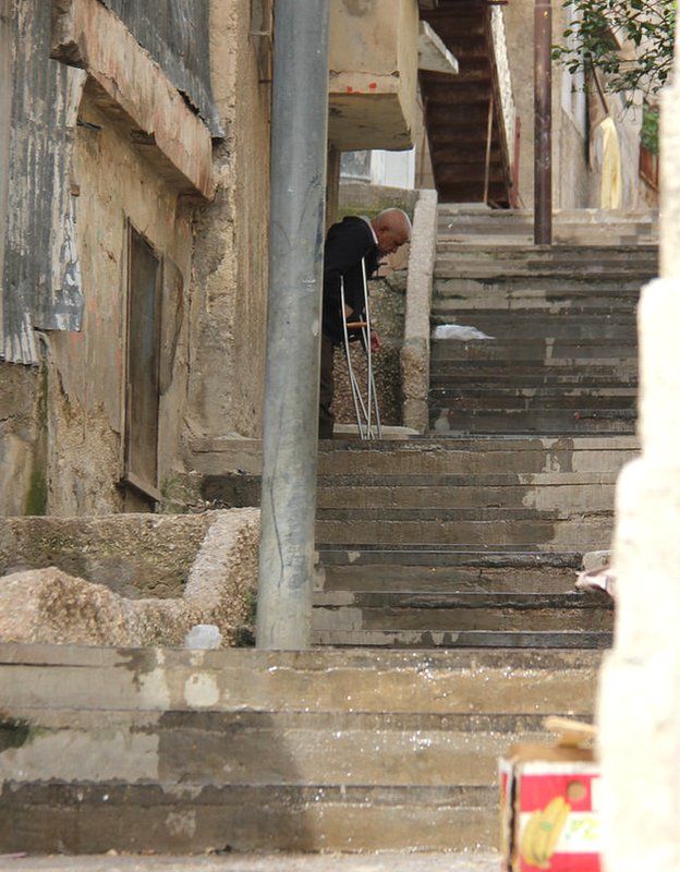 Disabled man part-way up a flight of stairs