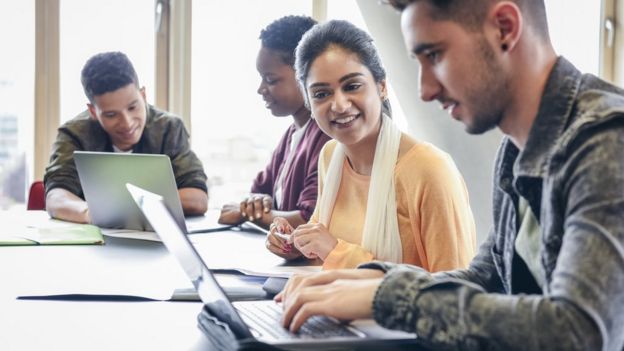 Jóvenes reunidos con computadores
