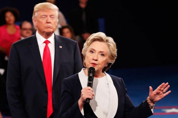 Donald Trump se para detrás de Hillary Clinton durante uno de los debates presidenciales.