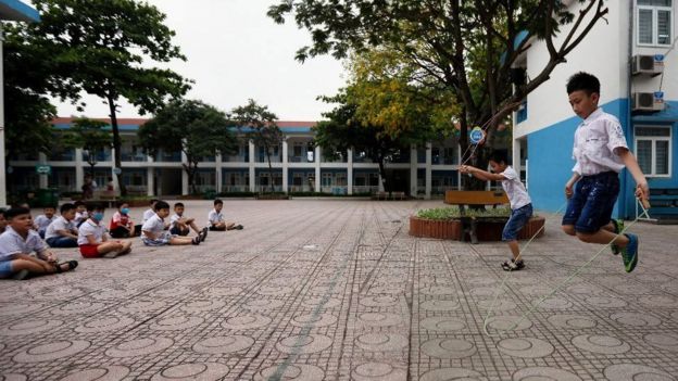 Crianças fazem ginástica no pátio da escola