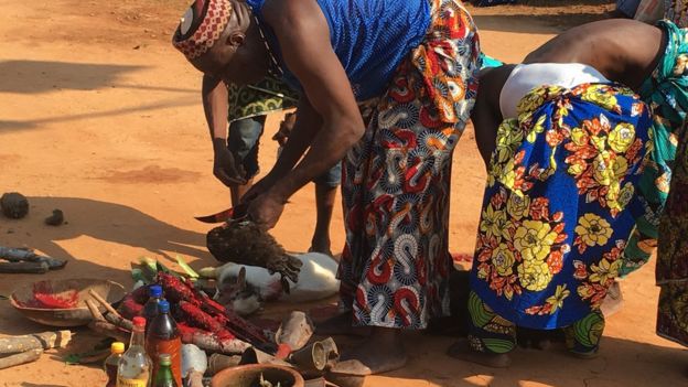 A man slaughter a chicken during a thanksgiving ceremony in Ouidah, Benin