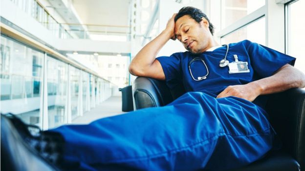 Médico cansado dorme em uma cadeira de hospital
