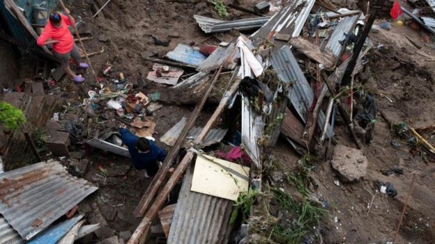 A woman and her son look at the rubble after their house was devastated by the overflowing of a creek due to the torrential rains caused by the passage of tropical storm Amanda in San Salvador on May 31, 2020.