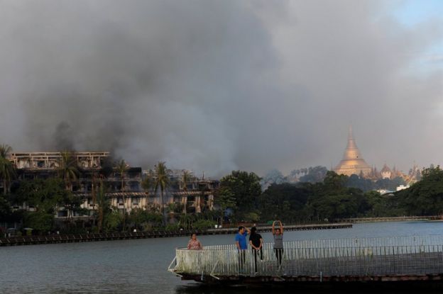People do exercises near a fire at Kandawgyi Palace hotel in Yangon, Myanmar October 19, 2017 .