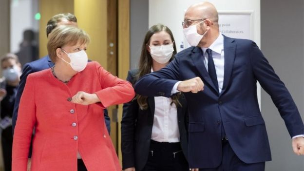 German Chancellor Angela Merkel (L) elbow bumps the President of the European Council Charles Michel (R) during an EU summit on July 17, 2020 in Brussels, Belgium.