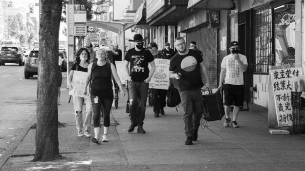 Participants in an August memorial march for victims of the overdose crisis walk through Vancouver streets