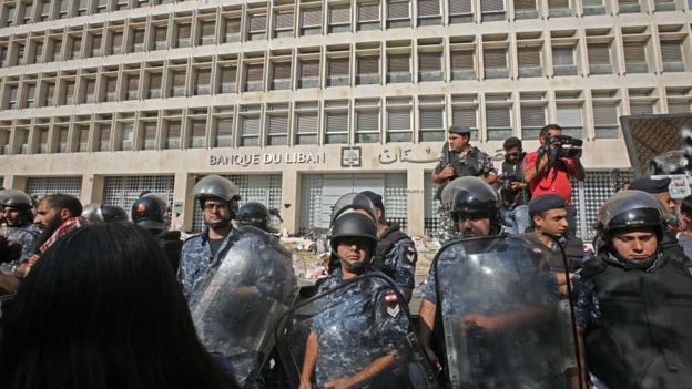Lebanese security forces secure the entrance of the Central Bank after anti-government protesters broke down a construction barrier as they rally at the same time of a press conference held by the bank's governor in Beirut on November 11, 2019.