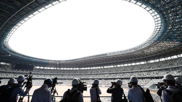 Media assess construction work at the Tokyo National Stadium earlier in July