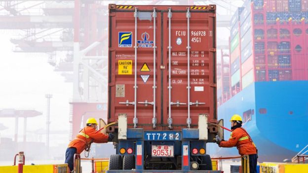 Workers prepare a container at a Chinese port in 2019