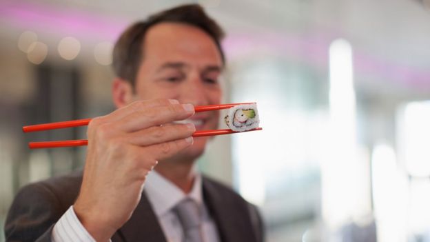 Un hombre comiendo sushi