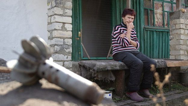 Жінка біля зруйнованого будинку