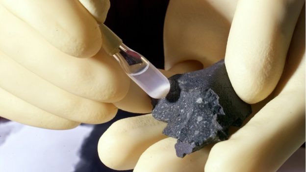 Científico analizando un fragmento de meteorito