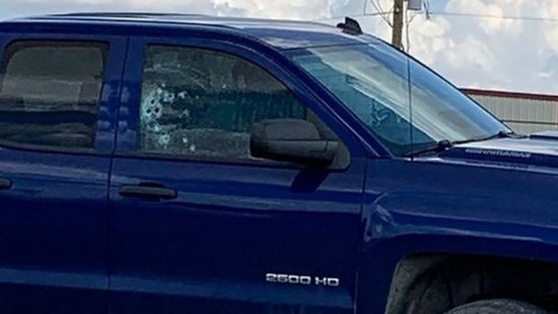 A truck with bullet holes in its side window