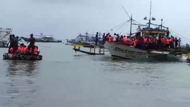Passengers of a capsized ferry are brought ashore off the coast of the Philippines