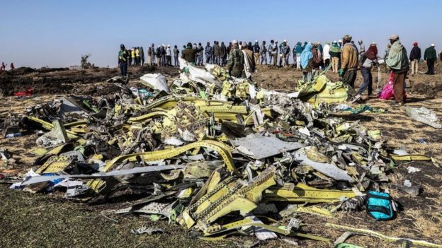 Personas frente a los restos del avión Boeing 737 MX de Ethiopia Airlines.