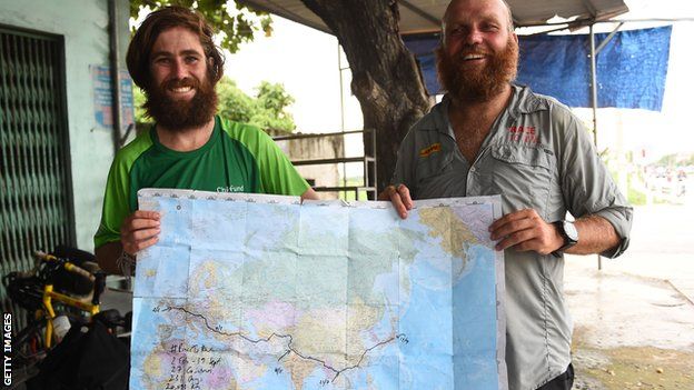 James Owens and Ron Rutland hold up a map of their journey