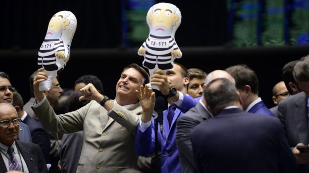 Jair Bolsonaro e Eduardo Bolsonaro com bonecos representando Lula preso, em 2016, no plenário da Câmara