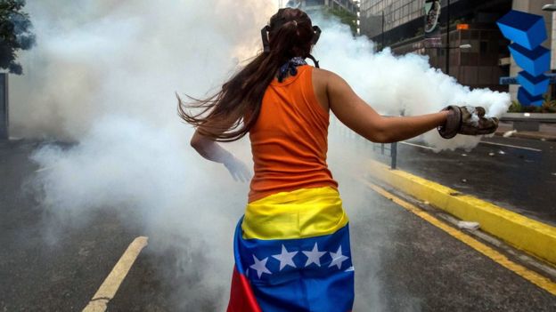 Manifestante com bomba na mão na Venezuela