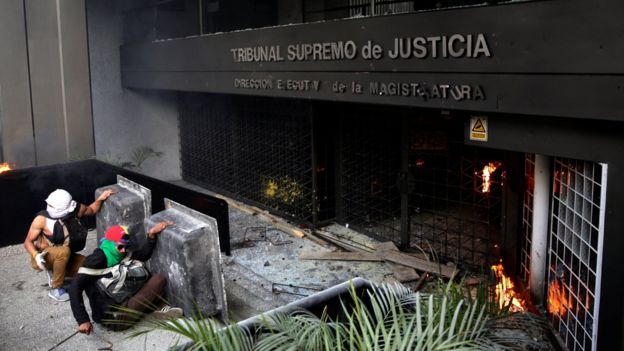 Un grupo de manifestantes lanzaron objetos contundentes hacia la fachada de una de las sedes del Tribunal Supremo de Justicia, en el este de Caracas.