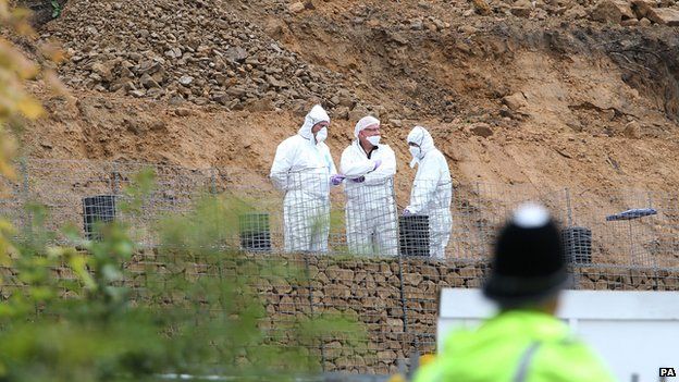 Forensic scientists in white overalls analysing site