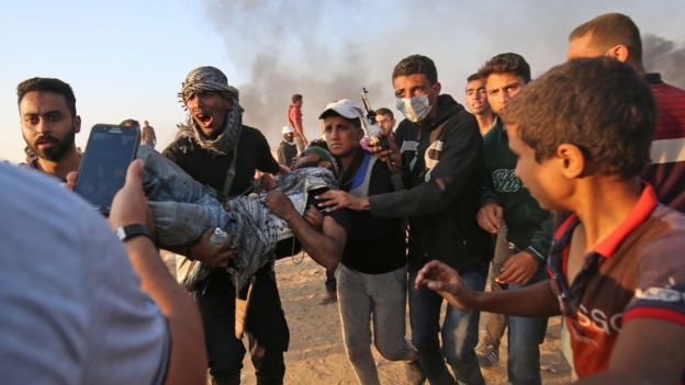 Palestinos trasladan a un herido durante las protestas del 15 de mayo