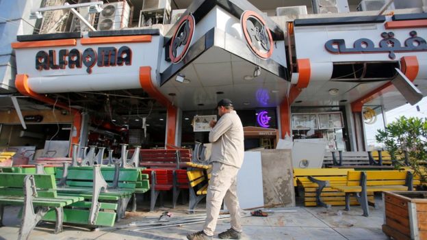 An Iraqi man inspects the site of a car bomb exploded near a cafe in Baghdad. May 30, 2017