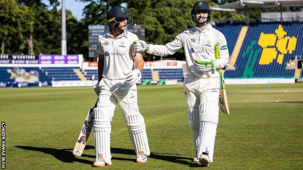 Colin Ingram and Edward Byrom of Glamorgan leave the field at the end of the day