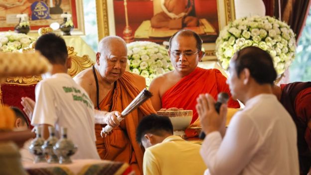 Um monge budista dá a benção a um dos 12 meninos