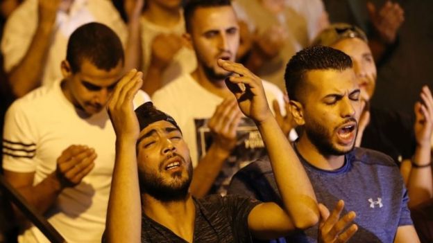 Mescid-i Aksa'nın girişinde dua eden Filistinliler