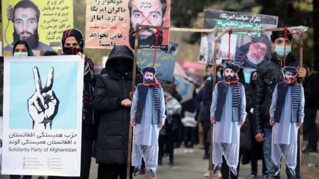 Afghan protesters carry the hanged effigies of freed prisoners Hanas Haqqani (C) and two other key Taliban key members as they shout slogans during a protest in Kabul, Afghanistan