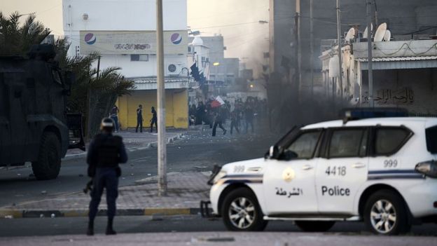 Bahraini protesters throw stones towards riot police during clashes in the village of Shahrakkan, south of Manama, on 5 April 2016