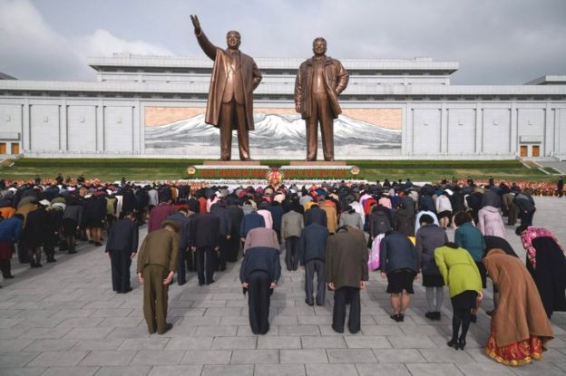 Los norcoreanos rinden tributo al monumento de Kim Il-sun y Kom Jong-il.