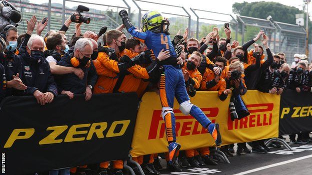 Lando Norris jumps into his team to celebrate after securing third place