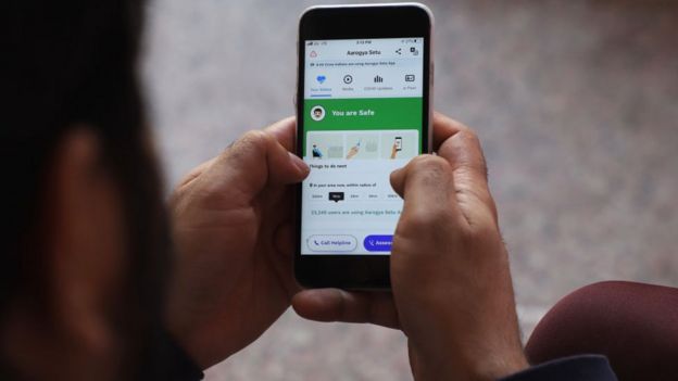 A man uses Aarogya Setu App on his mobile phone in New Delhi