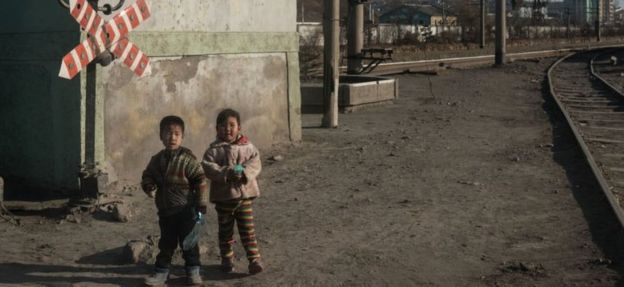 In a photo taken on November 21, 2017, children stand besides a railway track in the industrial city of Chongjin on North Korea's northeast coast.