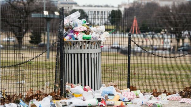 Garbage overflows a trash can on the National Mall across from the White House