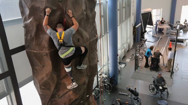 Veterano de guerra escalando en un rocódromo