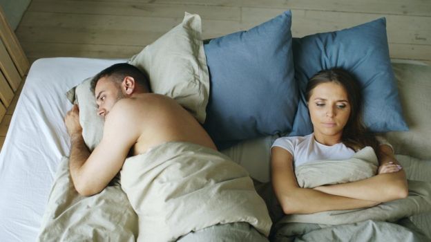 Homem e mulher deitados na cama