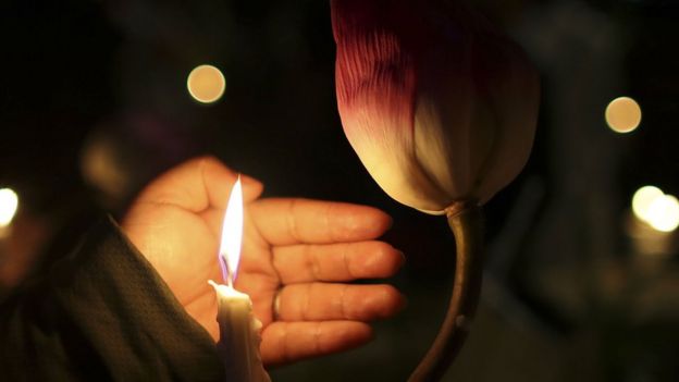 A woman holds a candle during a candlelight vigil paying tribute to the victims of the Sri Lanka bombings