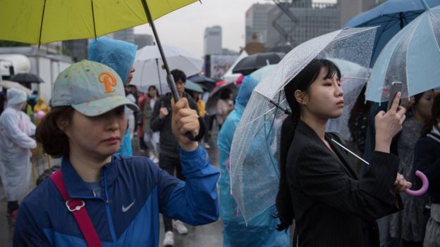 Южная Корея: несмотря на плохую погоду, люди собрались, чтобы первыми узнать результаты голосования