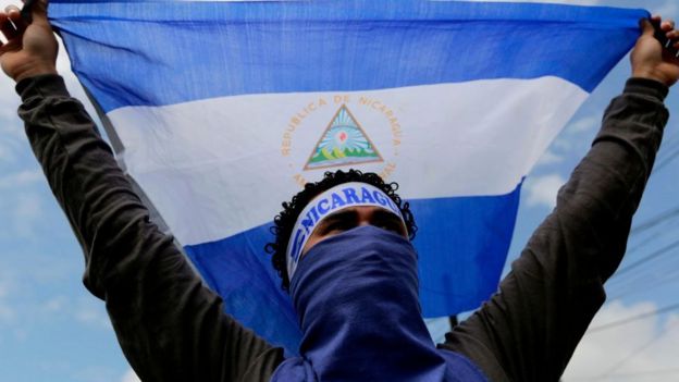 Un joven sostiene una bandera de Nicaragua.