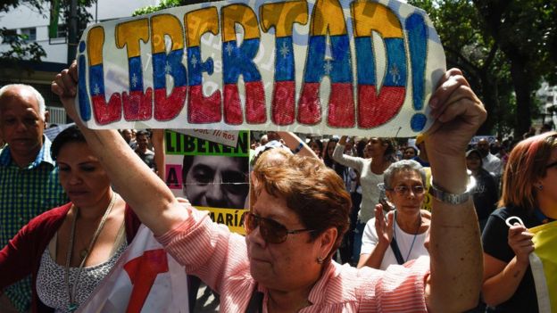 A demonstrator holds a sign reading "Freedom", during a protest against the government of President Nicolas Maduro, called by opposition leader and self-proclaimed "acting president" Juan Guaido on 30 January